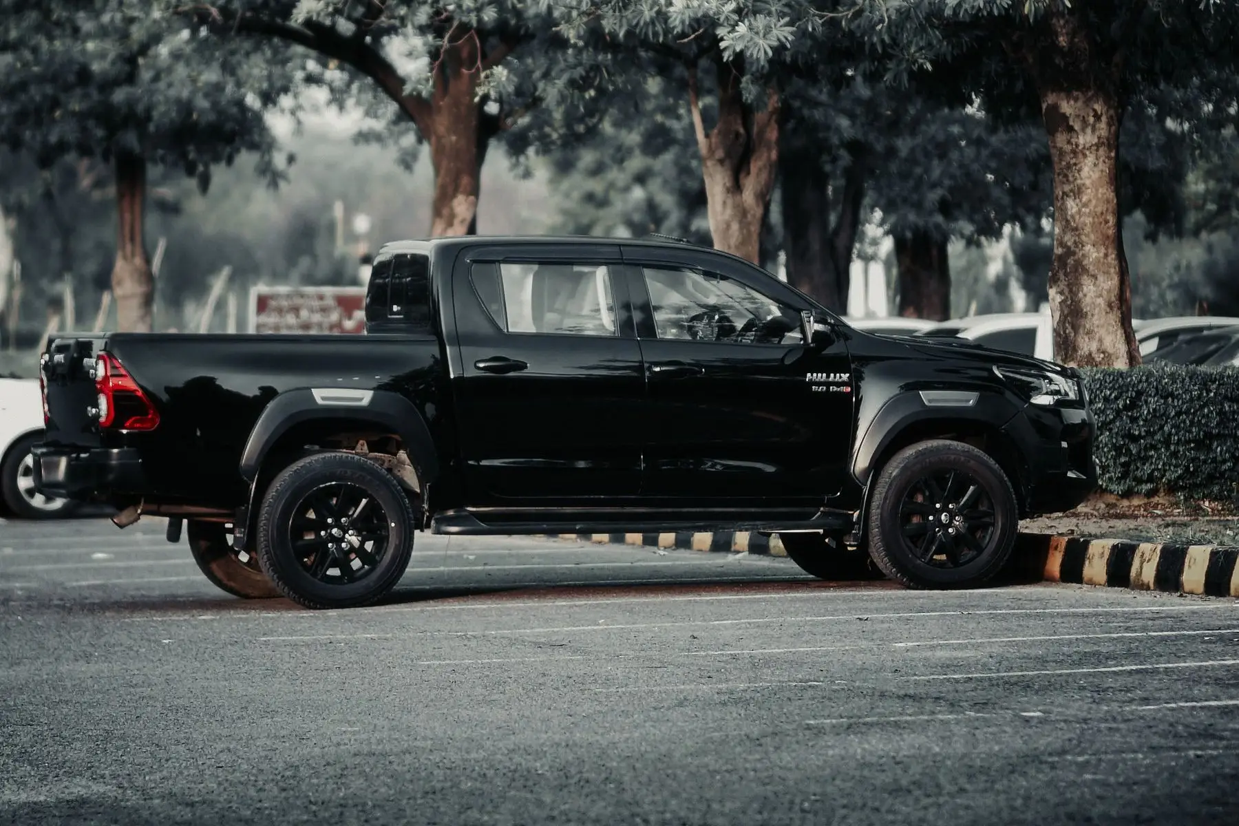 Toyota Hilux SR 2020. Toyota Hilux negra de perfil en un estacionamiento
