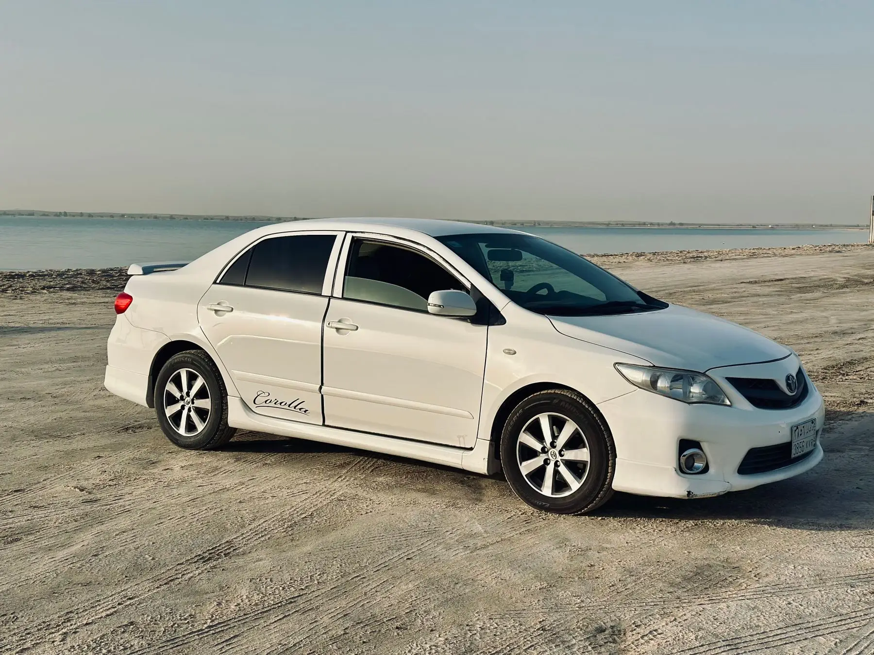 Toyota Corolla LE 2021. Toyota Corolla blanco de tres cuartos junto al mar
