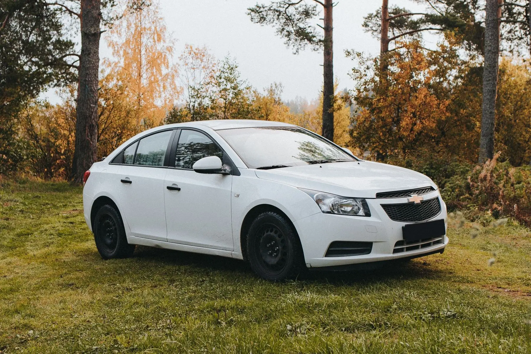 Chevrolet Onix LT 2021. Sedán Chevrolet blanco de tres cuartos sobre el pasto